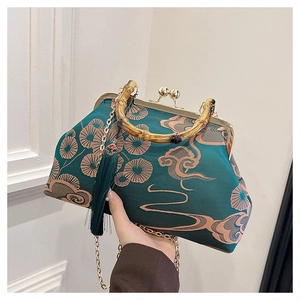 Detaillierte Makroansicht von Bambusgriff und Seidenstickerei auf der dunkelblauen Tasche
