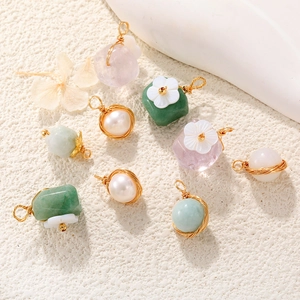 Macro shot of assorted stone pendants with gold wire wrap and floral accents