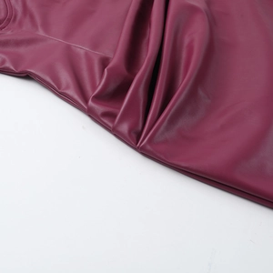 Gros plan sur le cuir synthétique bordeaux montrant la texture et les détails de couture