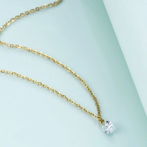 Close-up of minimalist gold chain necklace with a 6mm single white cubic zirconia pendant