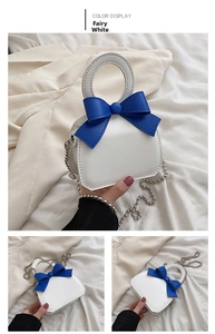 Detail view of Fairy White mini crossbody bag with blue bow and silver ball chain strap