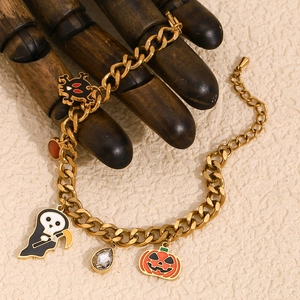 Detail of 18K gold plated Halloween charm bracelet with pumpkin and skull on Cuban chain