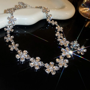 Sparkling silver flower necklace with clear zircons and diamonds on black surface
