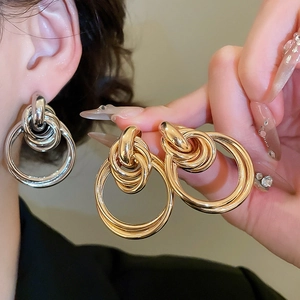 Gros plan de boucles d'oreilles nœuds polies en finitions or et argent pour femme