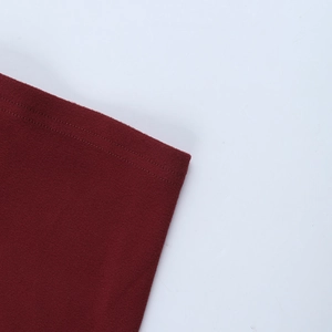 Dettaglio del vestito in maglia rosso scuro che mostra le cuciture doppie di qualità