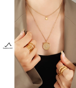 Close-up of double-layer stainless steel necklace set with sunburst and round coin pendants