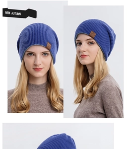 Detail view of navy blue knitted beanie with brown leather mountain logo patch