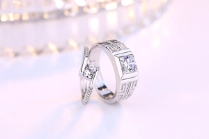 Detailed macro view of couple's rings with fretwork patterns and brilliant zircon stones