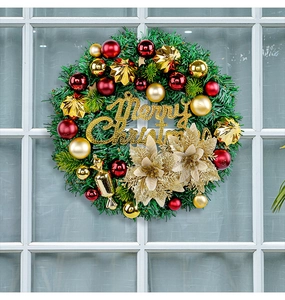 Detail of Christmas wreath with gold flowers, red baubles and Merry Christmas sign