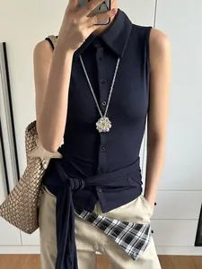 Close-up of a silver petal flower pendant necklace paired with a navy blue polo shirt