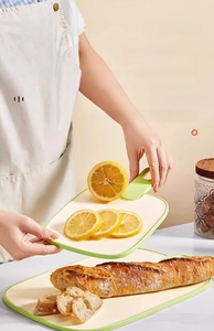 Kitchen cutting board with handle used as a serving tray for lemon and bread slices