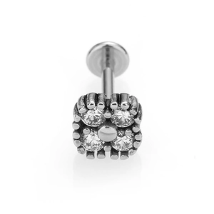 Macro detail of 316L stainless steel piercing jewelry with four zircons in clover pattern