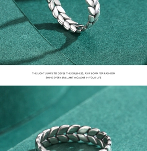 Macro shot of silver wheat ear textured ring band on green fabric background