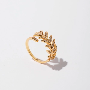 Detailed macro view of golden leaf feather ring with pavé micro-inlaid cubic zirconia