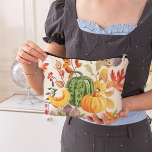 Borsa cosmetica in tela portatile con stampe di zucche e foglie autunnali tenuta a mano