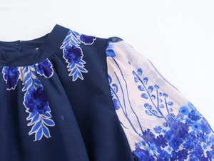 Close-up of elegant blue floral chiffon dress with sheer sleeves and neck detail