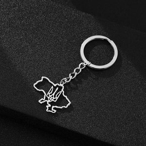 Detailed close-up of a silver Ukraine map pendant keychain with emblem on black background