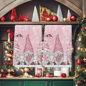 Pink Christmas kitchen towels featuring holiday gnomes and snowflakes hanging on a mantle