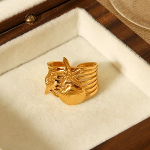 Details von 18 Karat Gold Seestern- und Muschelanhängern auf einem Edelstahlring