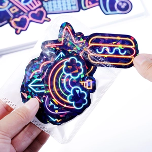 Close-up of holographic vinyl stickers featuring rainbow and neon icons in a clear pack