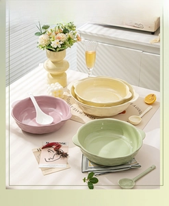 Detail of macaron ceramic soup bowls with double handles and spoons in a cozy kitchen setting