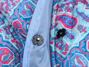 Detail of quilted cotton jacket with colorful ethnic paisley print and black snap buttons