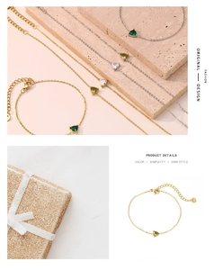 Detail of elegant gold bracelet with heart-shaped green gemstone on textured beige stone