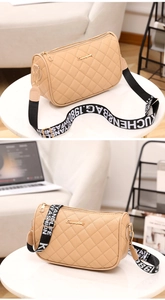 Close-up of beige quilted shoulder bag with contrast black wide logo fabric strap