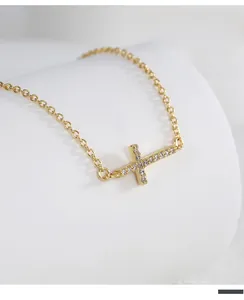 Macro shot of gold horizontal cross necklace featuring micro-pave clear cubic zirconia stones