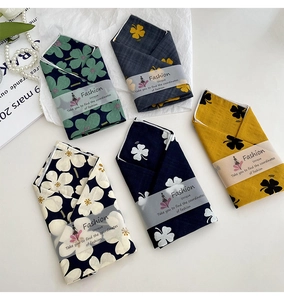 Close-up of five floral cotton linen scarves with fashion paper bands and pearls