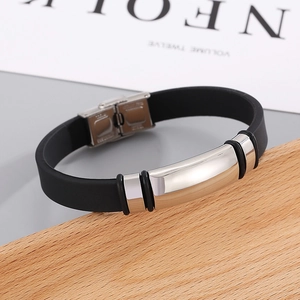 Macro shot of black silicone strap with silver steel buckle on a wooden stand