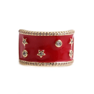 Close-up of a wide red enamel band ring with gold stars and sparkling zircon inlay
