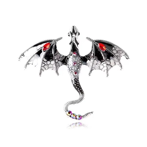 Detail of vintage dragon brooch with red gemstones and colorful rhinestones on metal scales