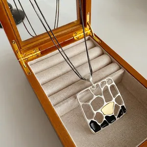 Double-layered chain necklace featuring a geometric matte pendant in silver and gold