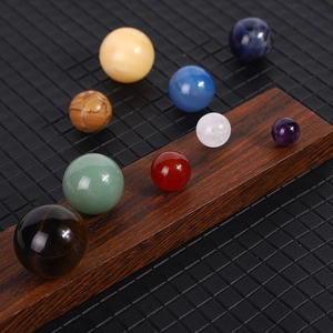 Solar system model with nine polished gemstone spheres on a wooden display base