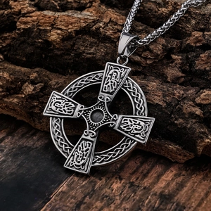Vintage Celtic cross pendant necklace with Nordic dragon carvings on dark wood background