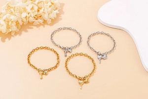Macro detail of gold and silver chunky chain bracelets with heart and key pendants