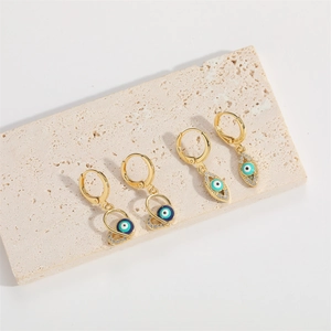 Boucles d'oreilles baroques œil bleu dorées avec zircons sur socle en pierre blanche