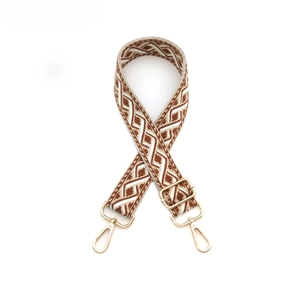 Détail d'une bandoulière à motif géométrique avec boucles et mousquetons dorés en métal