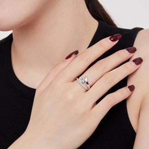 Macro detail of pear-cut gemstone ring on finger with micro-pave diamond band
