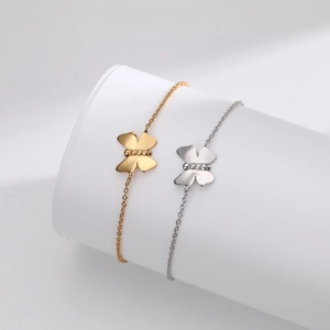Close-up of gold and silver butterfly pendant bracelets on white display stands