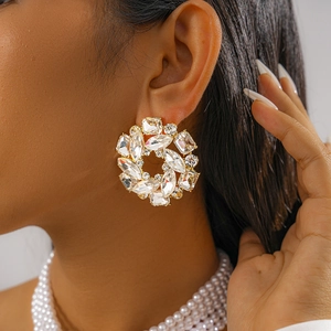 Close-up of elegant gold flower cluster earrings with sparkling crystal accents on model