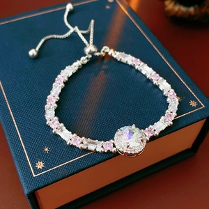 Detail of adjustable silver bracelet featuring pink zircons and a central halo crystal