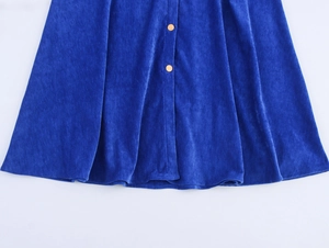 Dettaglio dell'abito in ciniglia blu reale con trama vellutata e bottoni dorati decorativi