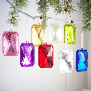 Colorful multifaceted acrylic gemstone pendants hanging on a Christmas tree branch