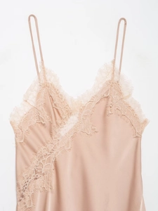 Close-up of champagne satin fabric and delicate eyelash lace trim on the neckline