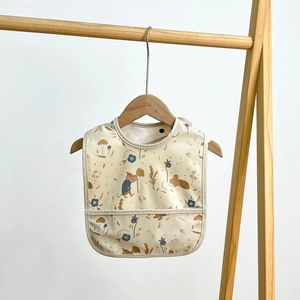 Waterproof baby bib with cartoon mouse pattern and food catcher pocket on wooden hanger