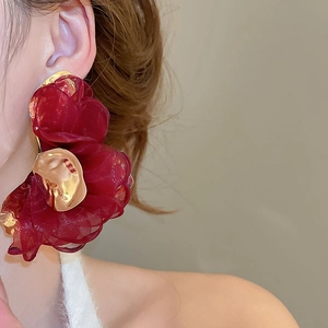 Close-up of elegant dark red chiffon flower earrings with textured gold metallic accents