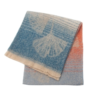 Close-up of woven ginkgo leaf pattern on a blue, beige and orange gradient scarf