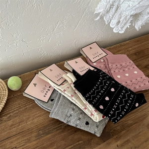 Détails de tricot avec motifs de flocons et cœurs sur des chaussettes en coton